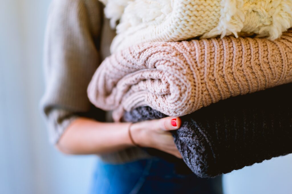 person carrying folding bedlinens