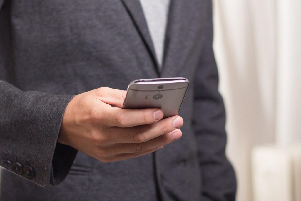 man in suit holding cell phone